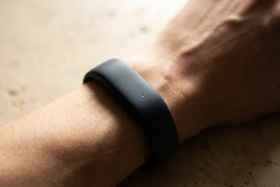 A wearable band on a wrist showing an 86 percent recovery readout